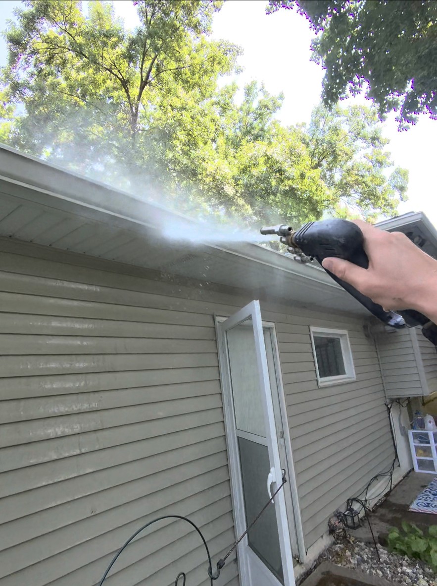 Spotless Wash rinsing house siding and eaves with a washing wand
